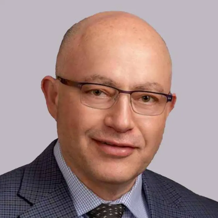 Portrait of a middle-aged man with glasses and a suit.